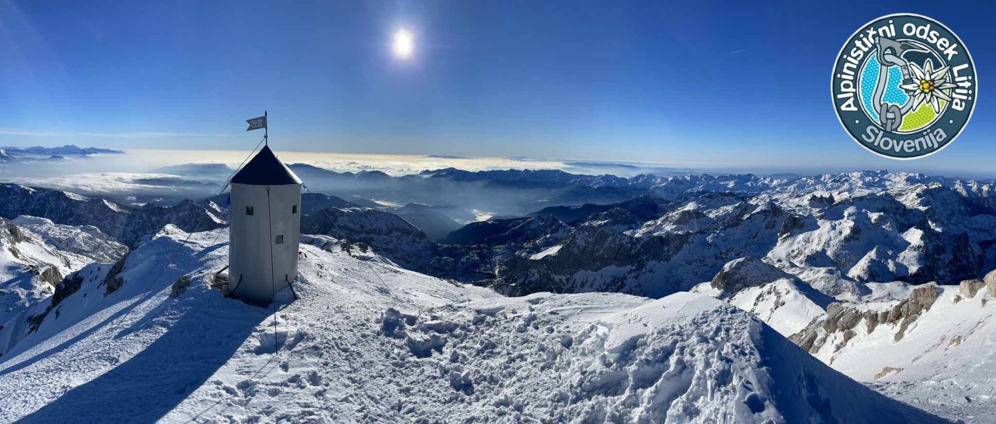 Naslovna slika spletne platforme AO Litija — zasnežen vrh z gorsko kočo